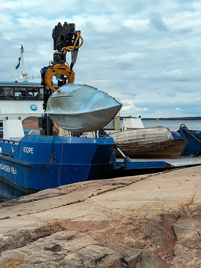 M/S Roope nostaa venettä romunkeräysaluksen kannelle.